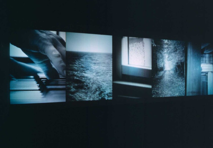 Five illuminated rectangular panels show a hand on piano keys, rough sea, window, and dark pathway.