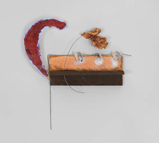 Wall-mounted mixed-media sculpture with a red curved shape, wooden boards, wire, and crumpled paper.