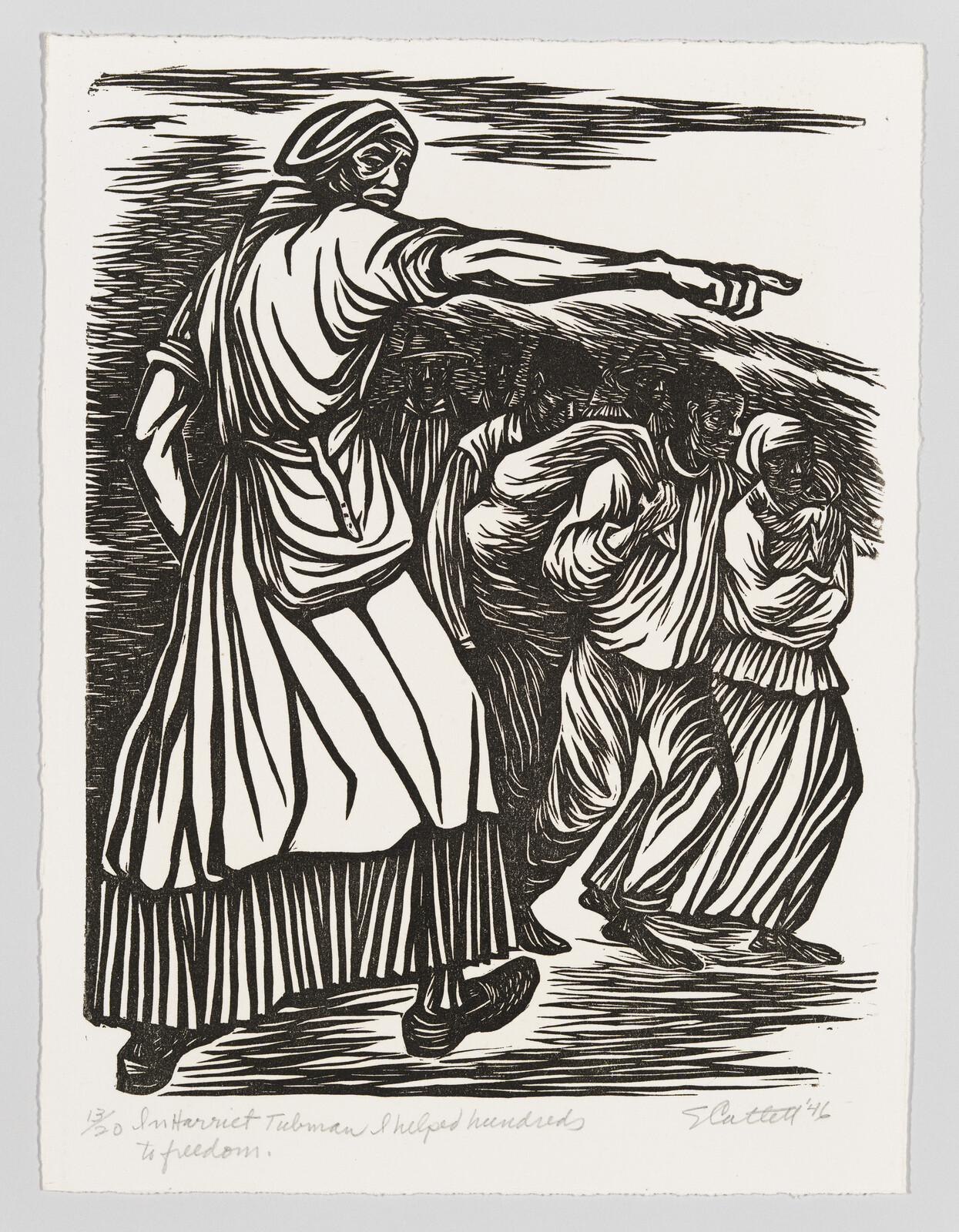 A woman points forward, leading a group of people walking closely behind her.