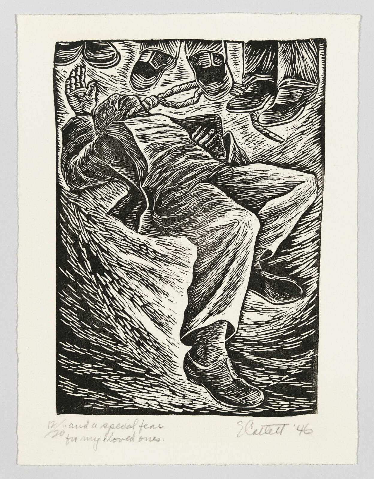 A Black man lies on the ground with a rope around his neck, while the feet of three unseen figures appear at the top of the frame, standing on the rope.