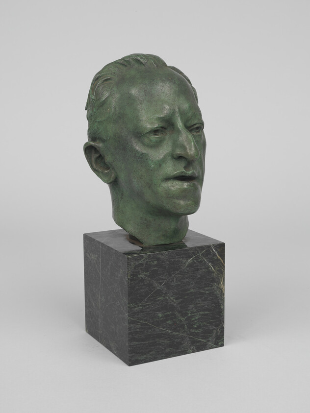 Bronze-green sculpted male head with calm expression mounted on a dark marble square base.