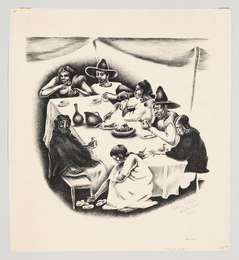 Seven people sit around a table under a tent sharing food while a woman washes someone's feet.