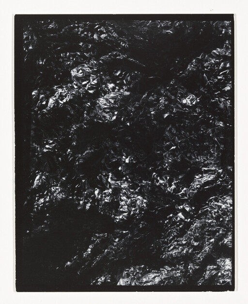 Crinkled black foil with reflective highlights framed by a narrow white border.