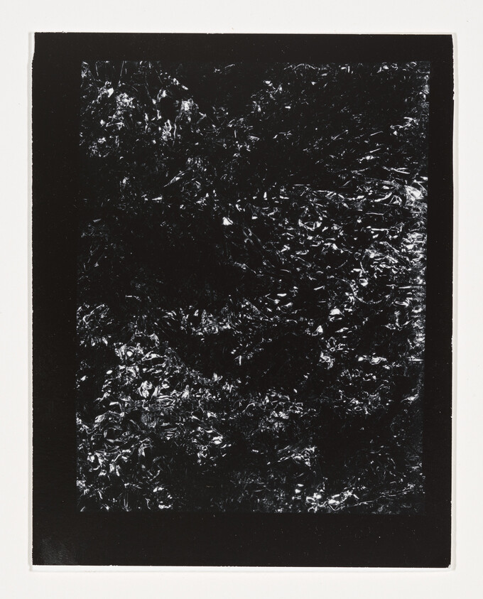 Black rectangular print shows crumpled reflective foil texture with bright highlights against dark background.