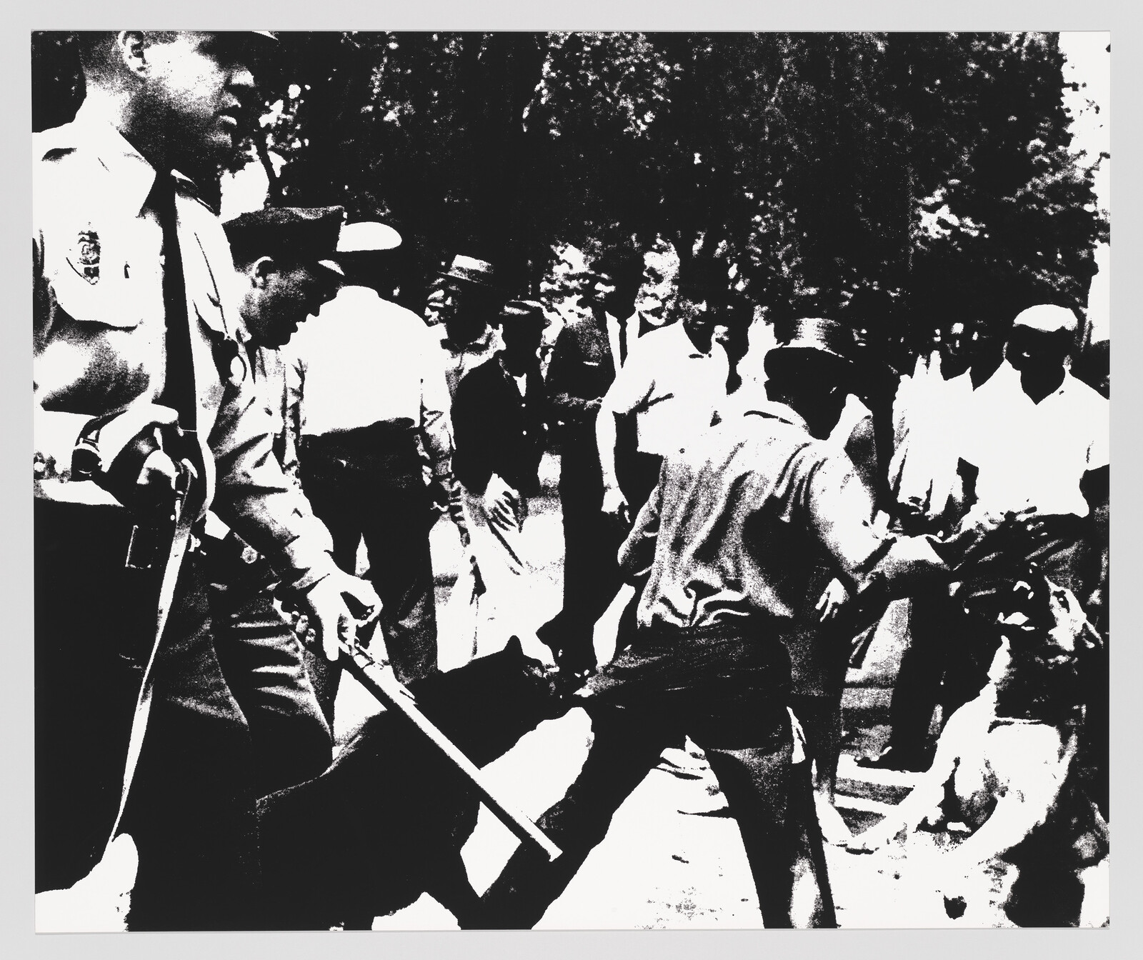 Black and white photo of a confrontation between a police officer and a group of people.