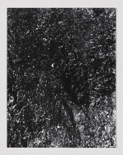 Crumpled black foil with shiny, irregular creases covering the entire rectangular frame.
