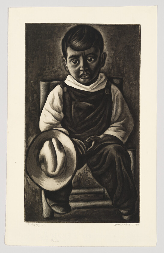 A young boy sits on a chair holding a wide-brimmed hat and looking solemnly forward.