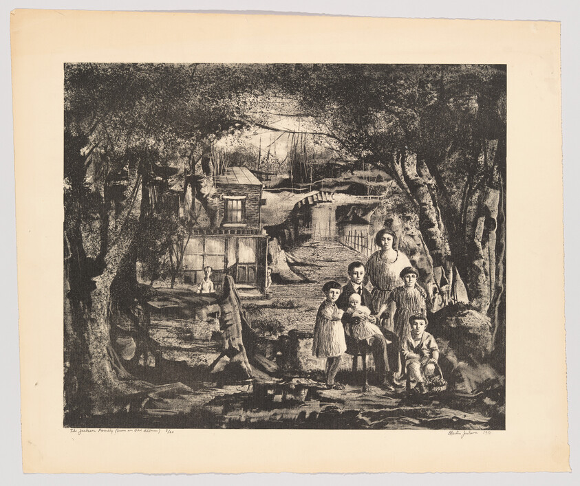 A woman and five children stand in a wooded clearing with a house and bridge behind them.