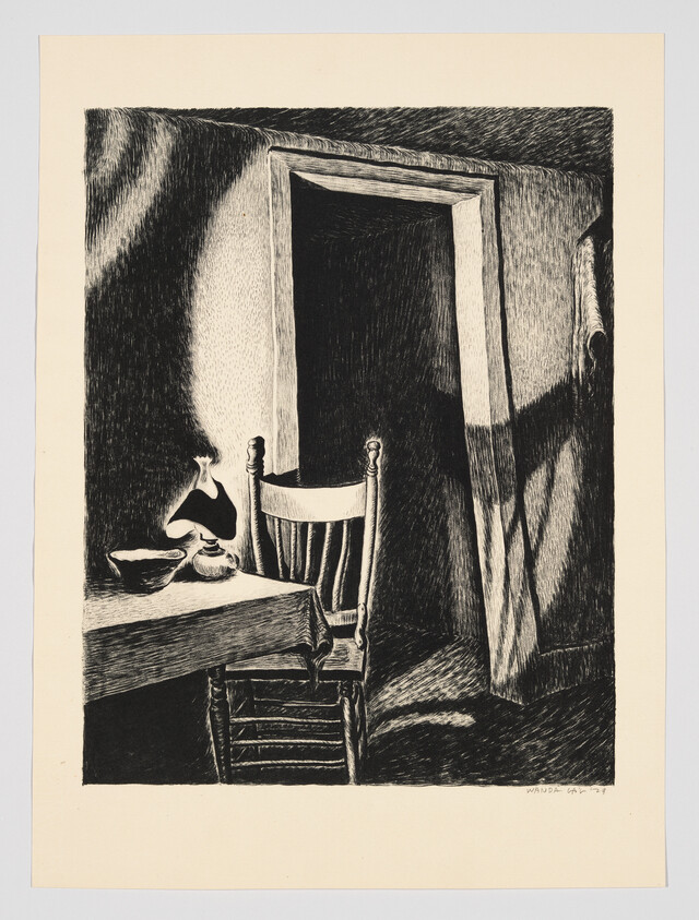 A wooden chair sits by a table with a lamp and bowl, next to an open doorway.