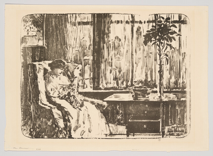 A woman sits in an armchair by a window, quietly reading a book beside a table and plant.