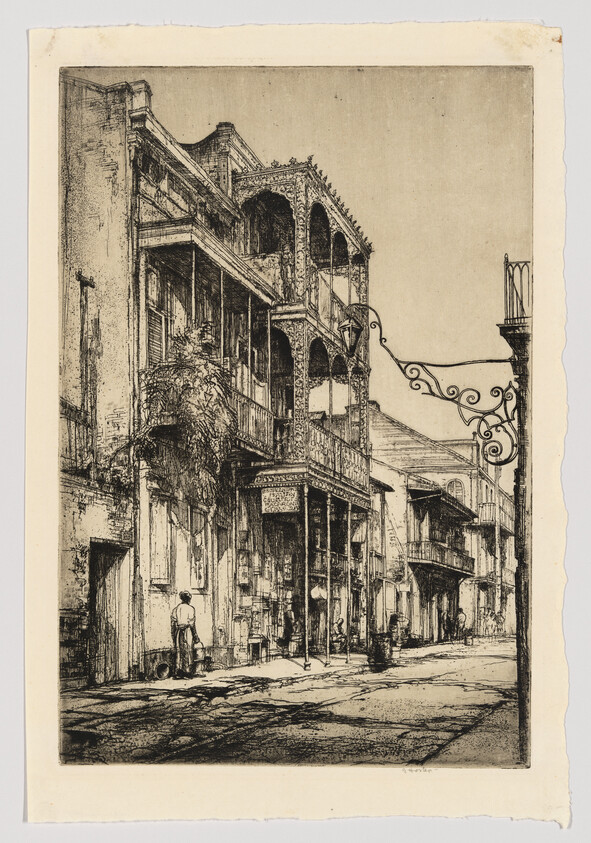 A detailed etching depicting an old street scene with two-story buildings featuring ornate balconies and arched windows. A lone figure stands on the sidewalk near a street lamp, and the textures of the architecture and cobblestone street are finely rendered, suggesting a historical or European setting. The edges of the paper are rough, indicating it may be a print.