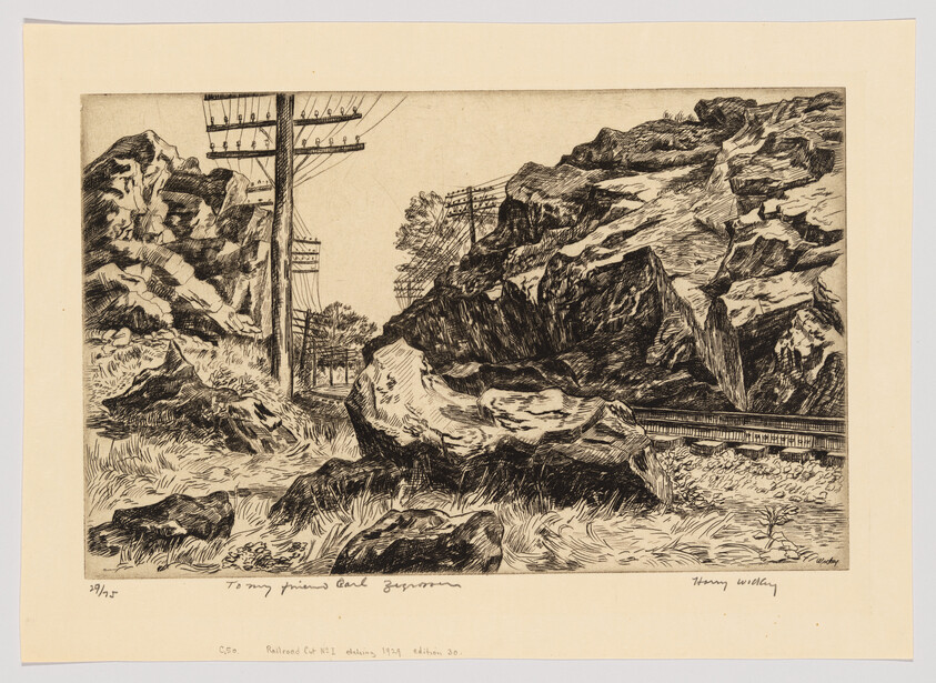 Rocky railroad cut with large boulders and telegraph poles beside the train tracks.