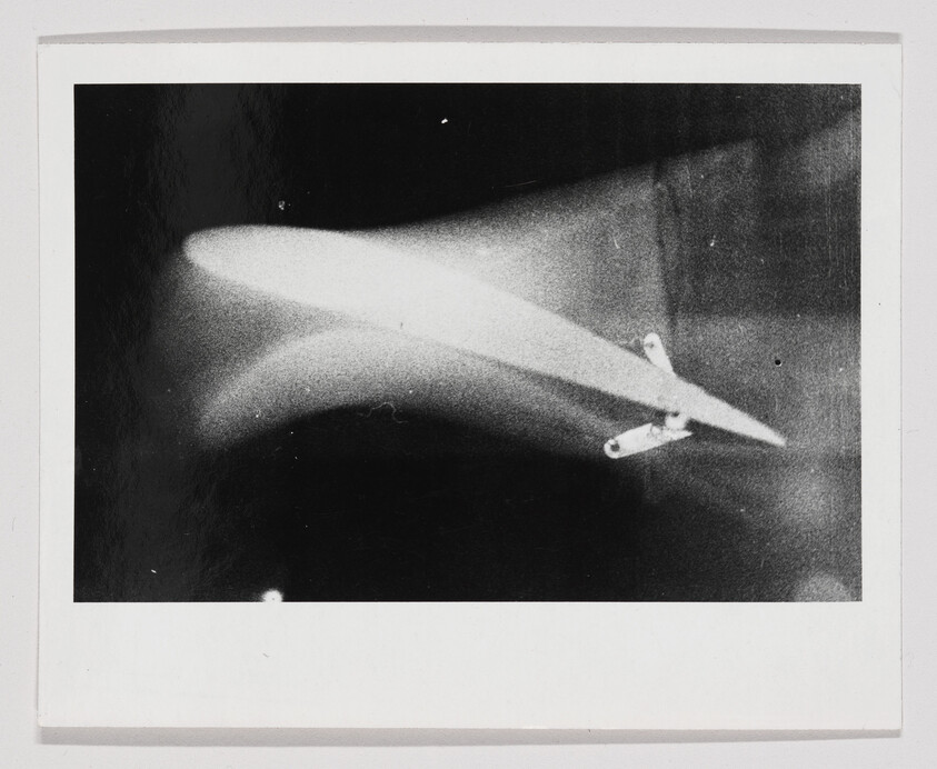 X-ray showing a long metal foreign object with two small metal fasteners inside soft tissue.