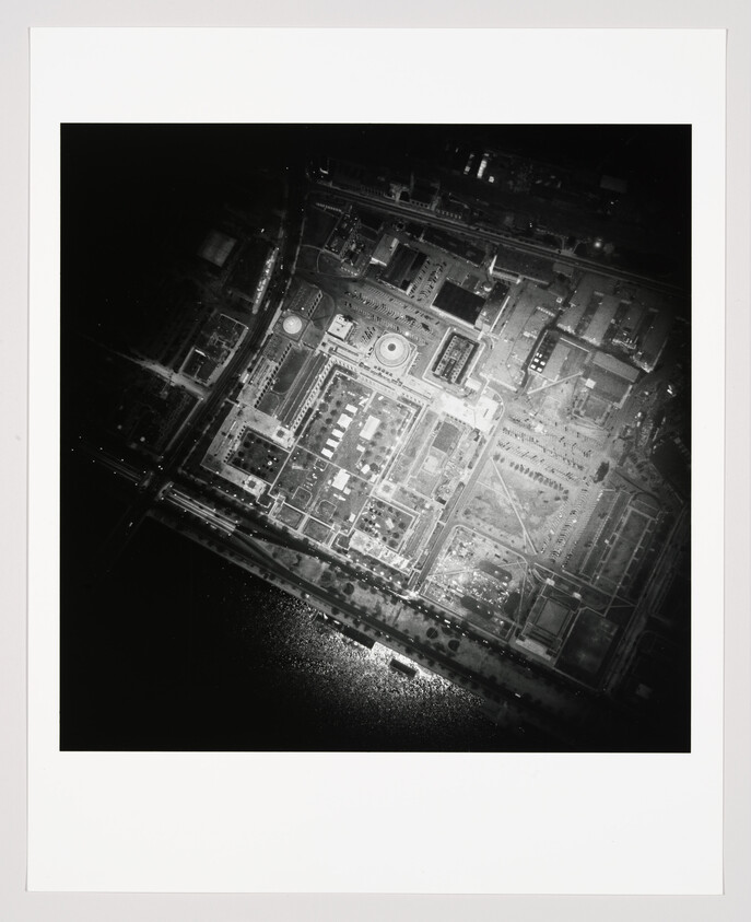 Aerial view of a square government complex with a central domed building beside a waterfront.