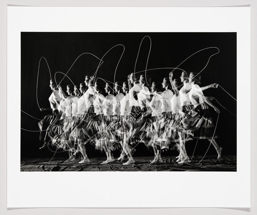 A woman repeatedly jumping rope captured in overlapping multiple exposures and sweeping light trails.