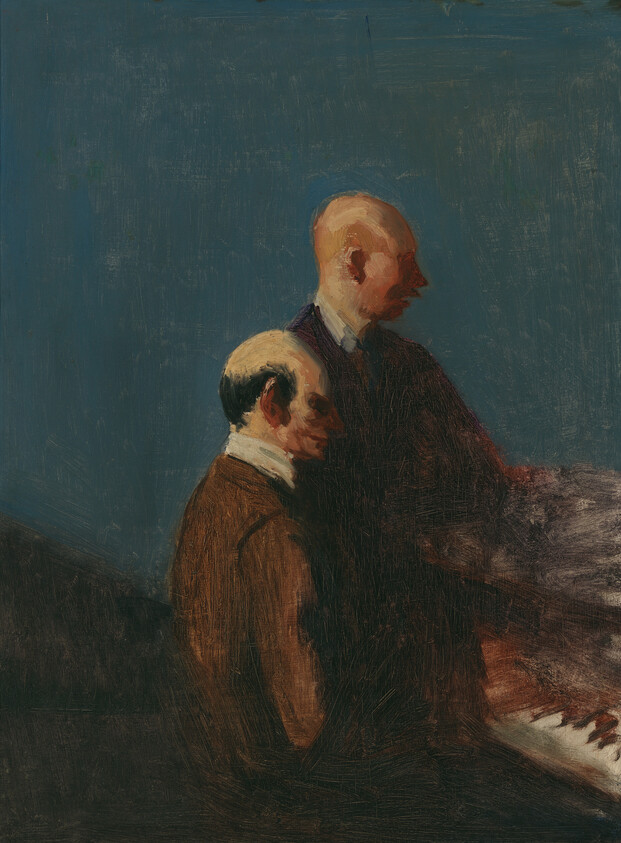 Two men in dark suits sit beside a piano against a blue background, one appearing to play.