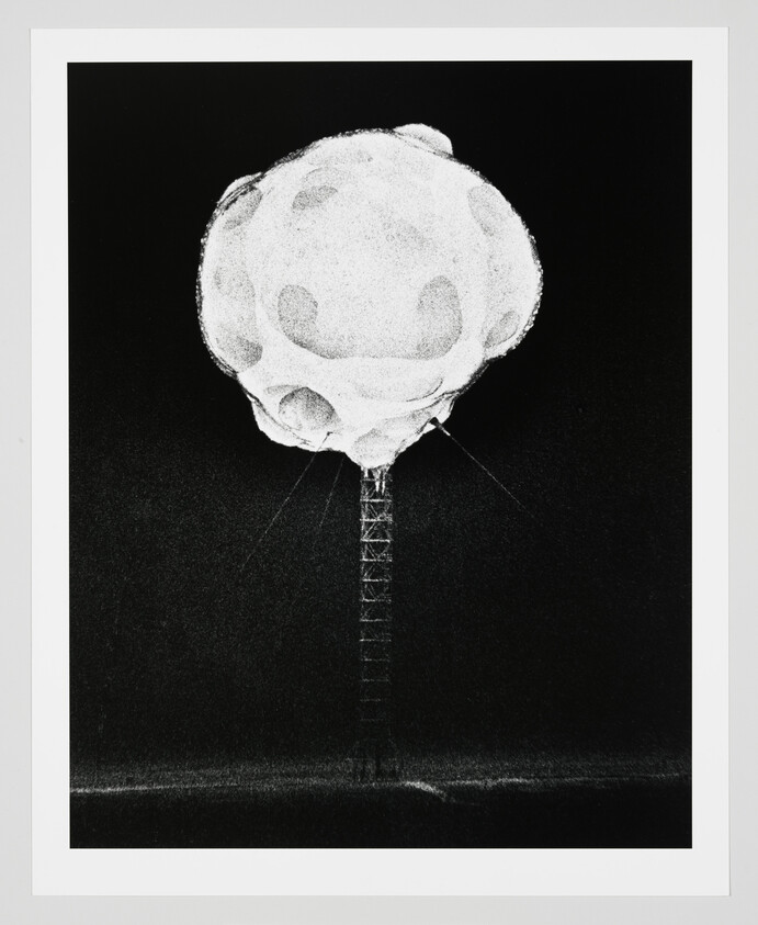 A large white spherical object with crater-like markings sits atop a tall lattice tower against a dark sky.