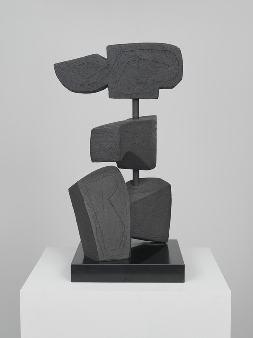 Abstract dark stone-like blocks stacked on a metal rod mounted on a black base.