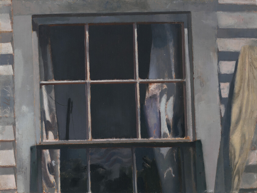 A worn wooden window with six panes showing a dark interior and partly drawn curtains.