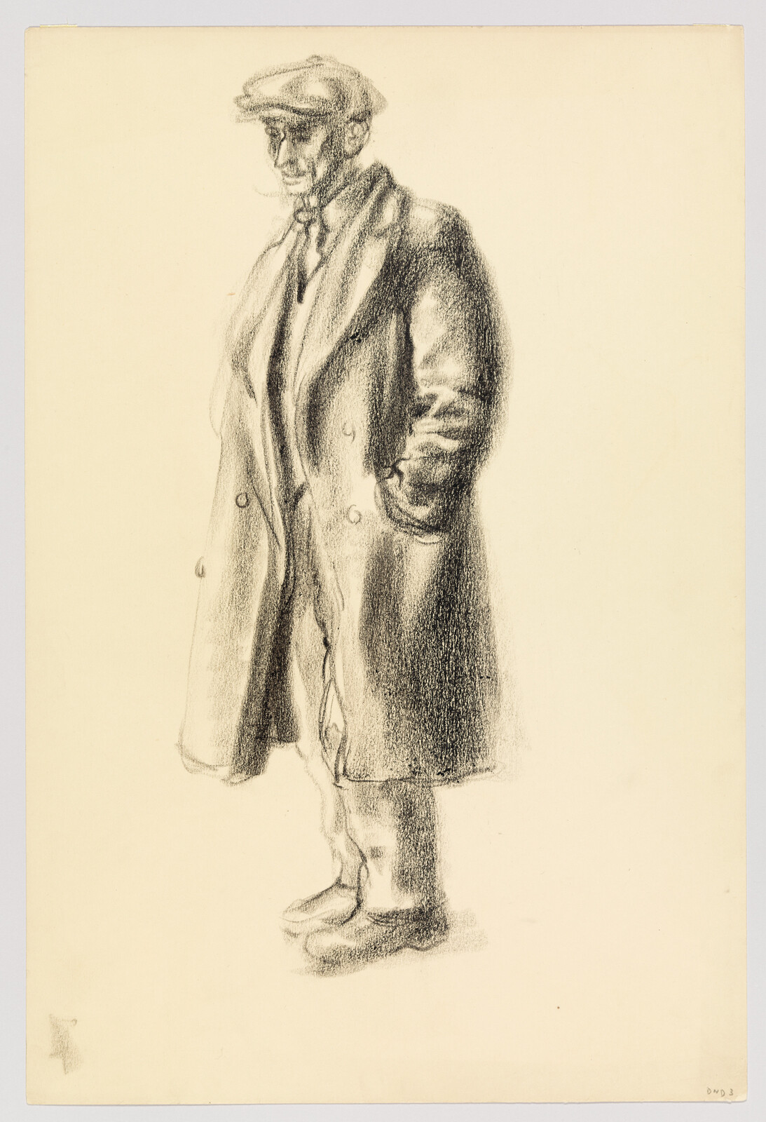 An older man in a long coat and flat cap stands with his hands in his pockets.