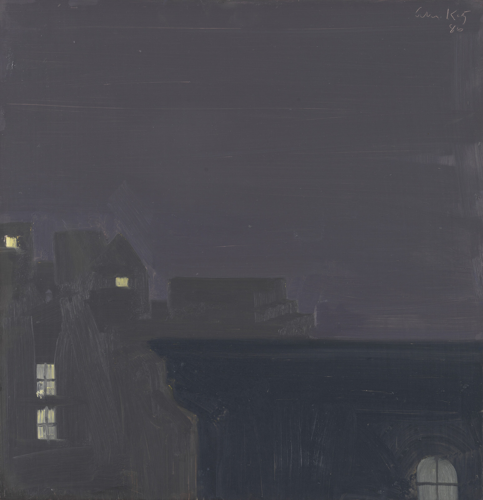 Dark coastal town at night with a few illuminated windows and a calm sea.