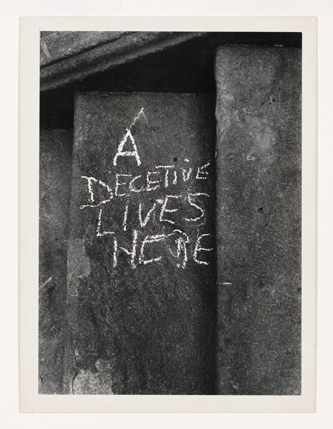 Chalk message on concrete steps reading "A defective lives here," scrawled in uneven letters.