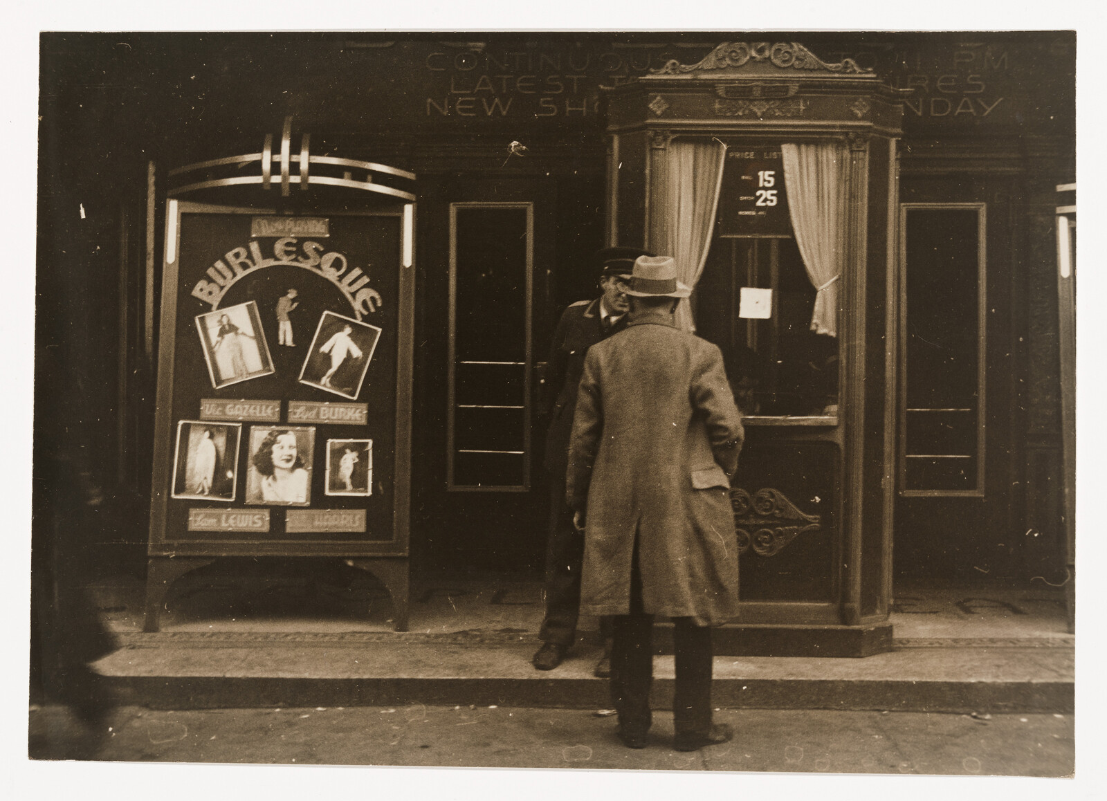 A man buys a ticket at a burlesque theater box office while another attendant speaks.