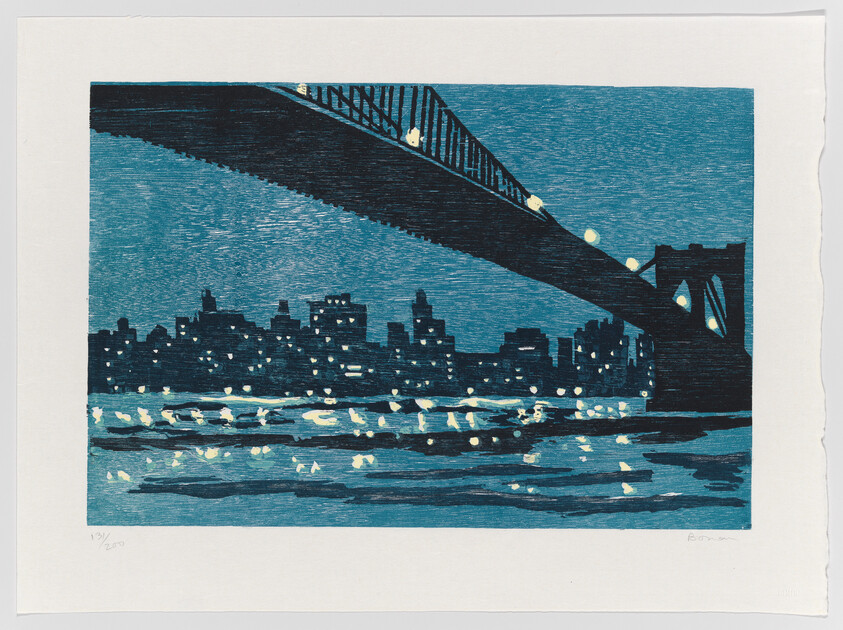 Large arched bridge crosses over a lit city skyline with lights reflecting on the water.