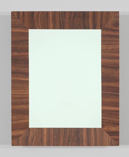 Large rectangular mirror with a wide polished walnut frame hanging on a light gray wall.