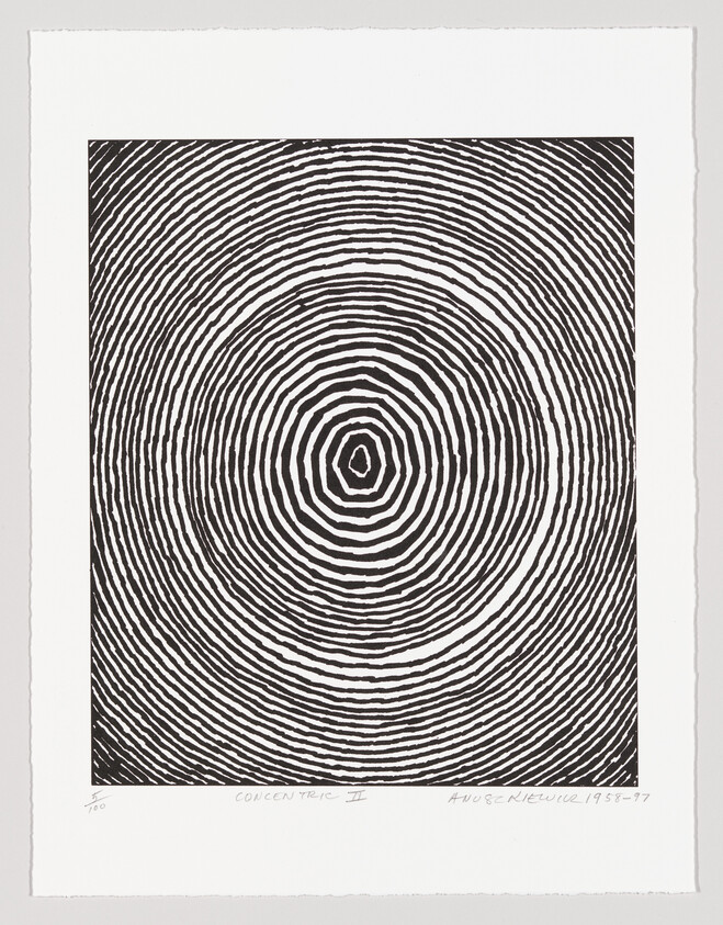 Black and white concentric rings forming an irregular bullseye pattern on a sheet of paper.