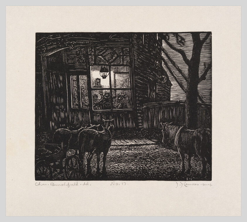 Several cows stand in a dark yard looking toward a warmly lit window of a house.