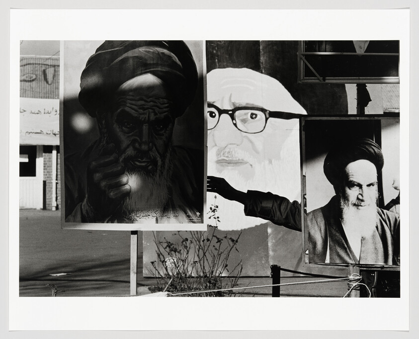 Three large portraits of religious leaders displayed on outdoor boards with an outstretched arm pointing.