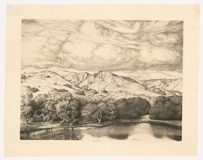 Rolling hills and trees reflect in a calm river under a swirling, cloud-filled sky.