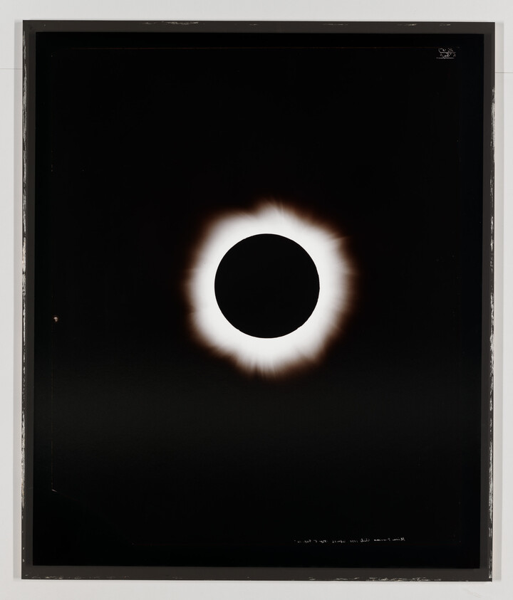 A total solar eclipse with the dark moon centered and a bright glowing corona around it.