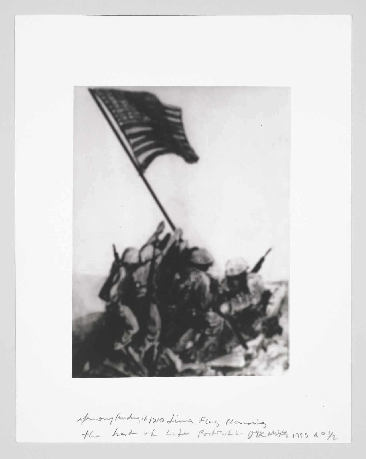 Soldiers climb a rocky hill while raising an American flag during a battle.