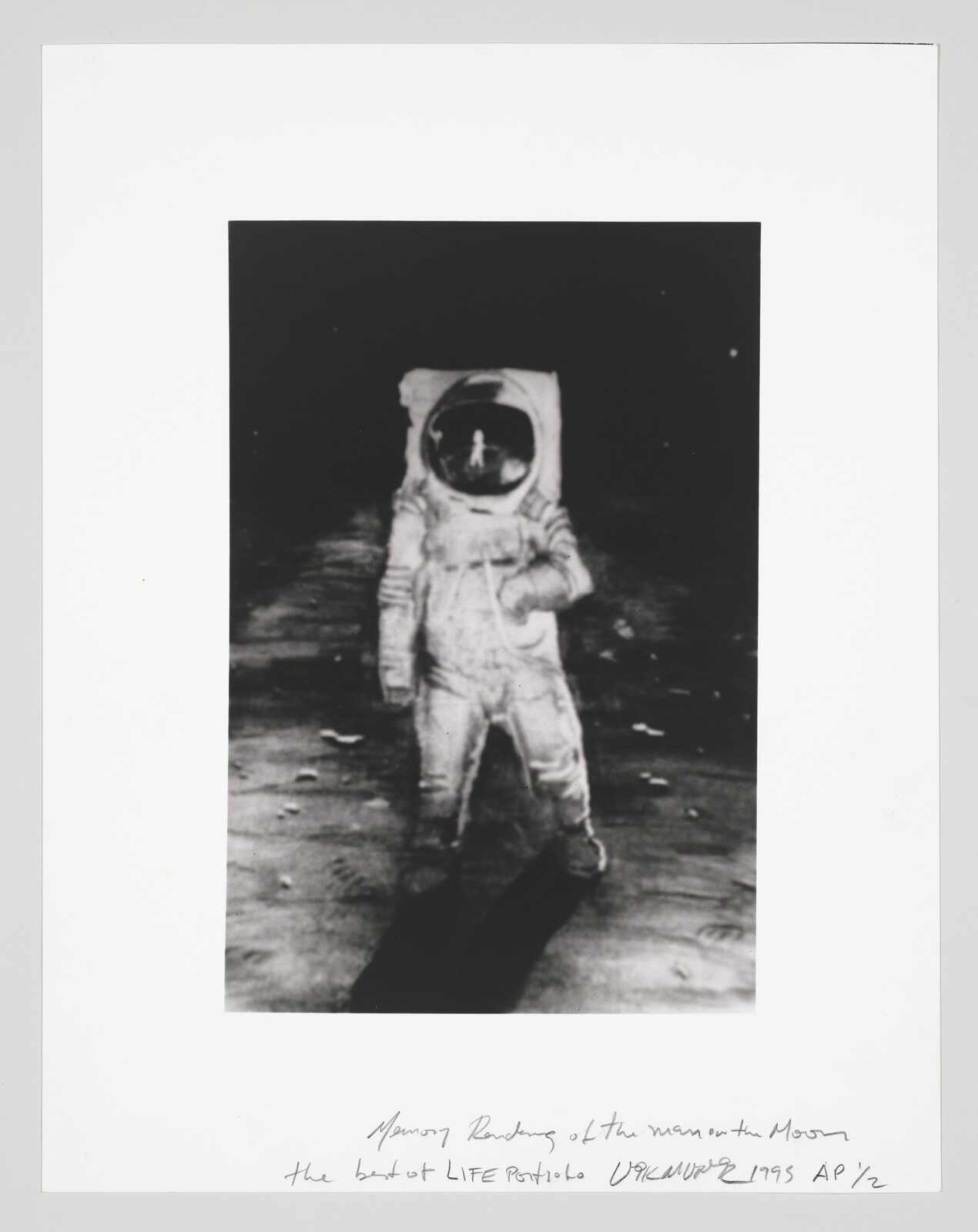 An astronaut in a bulky suit stands on the lunar surface with a helmet reflection.