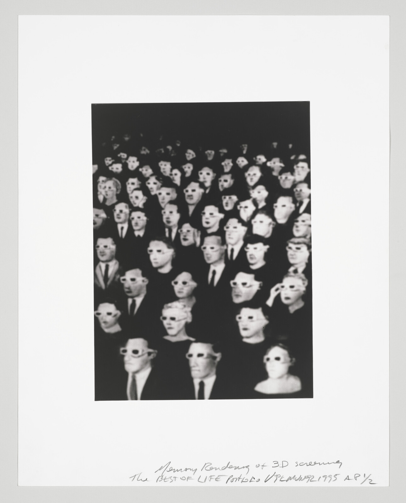 Crowd of people wearing 3D glasses seated and looking toward a screen.