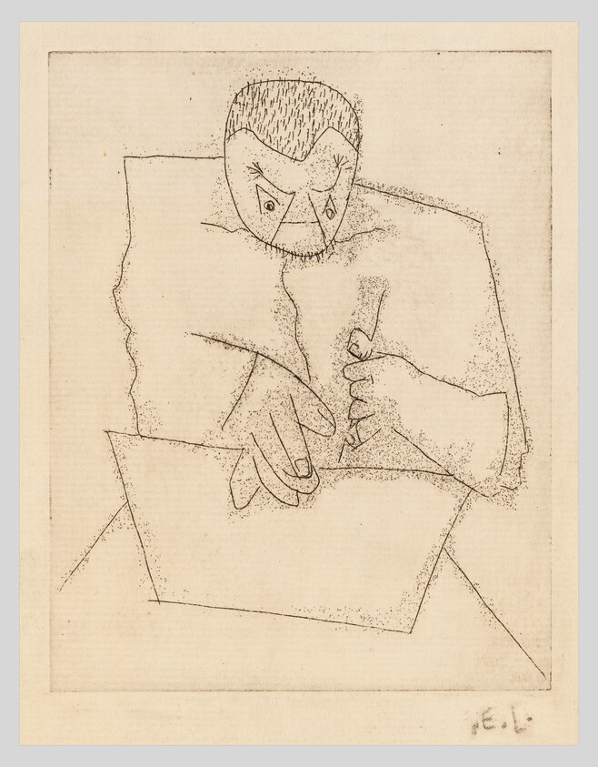 A person leaning over a sheet of paper, holding a pen and drawing or writing.