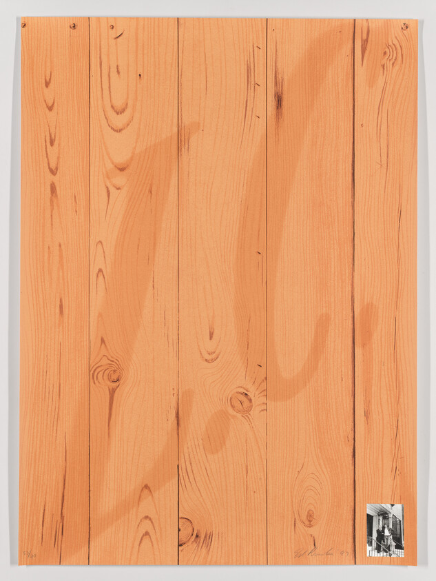 Large vertical wooden plank panel with visible grain and a small black-and-white photo attached bottom right.
