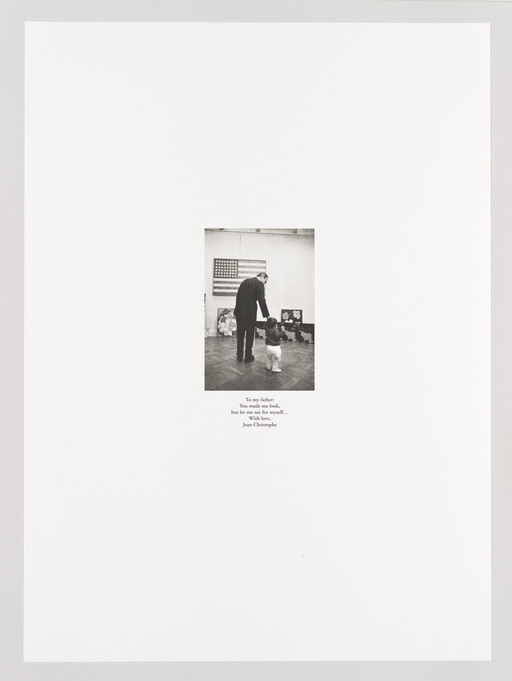 An older man holds a toddler's hand as they walk together in an art gallery.