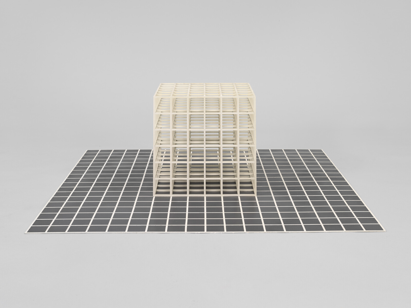 A wooden grid structure sits atop a black and white checkered floor against a neutral background.