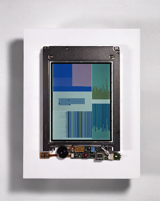 A digital screen with abstract colored shapes and lines, attached to exposed electronic components on a white background.