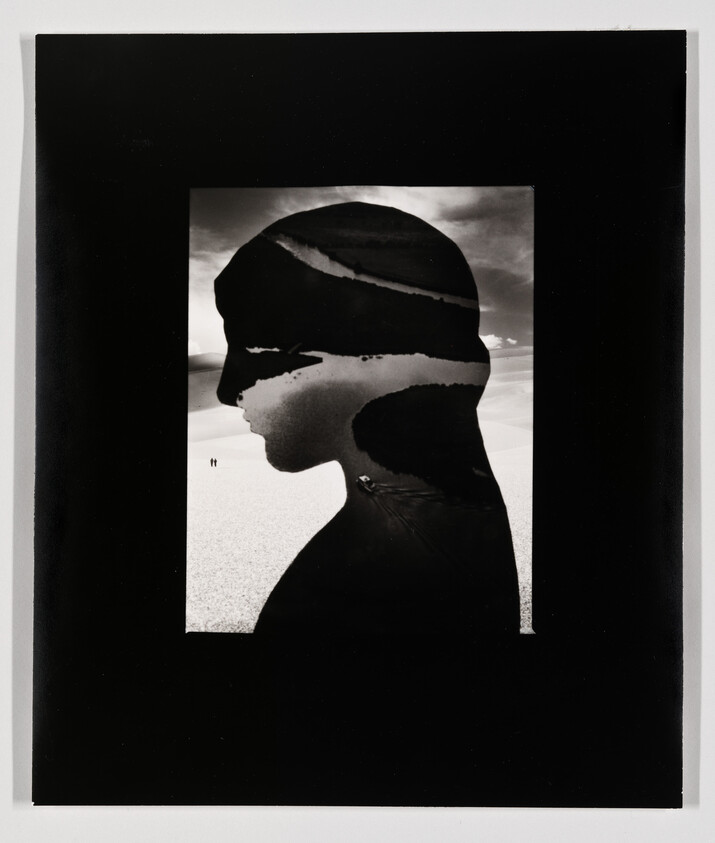 Silhouette profile filled with desert dunes and two tiny figures walking across the sand.