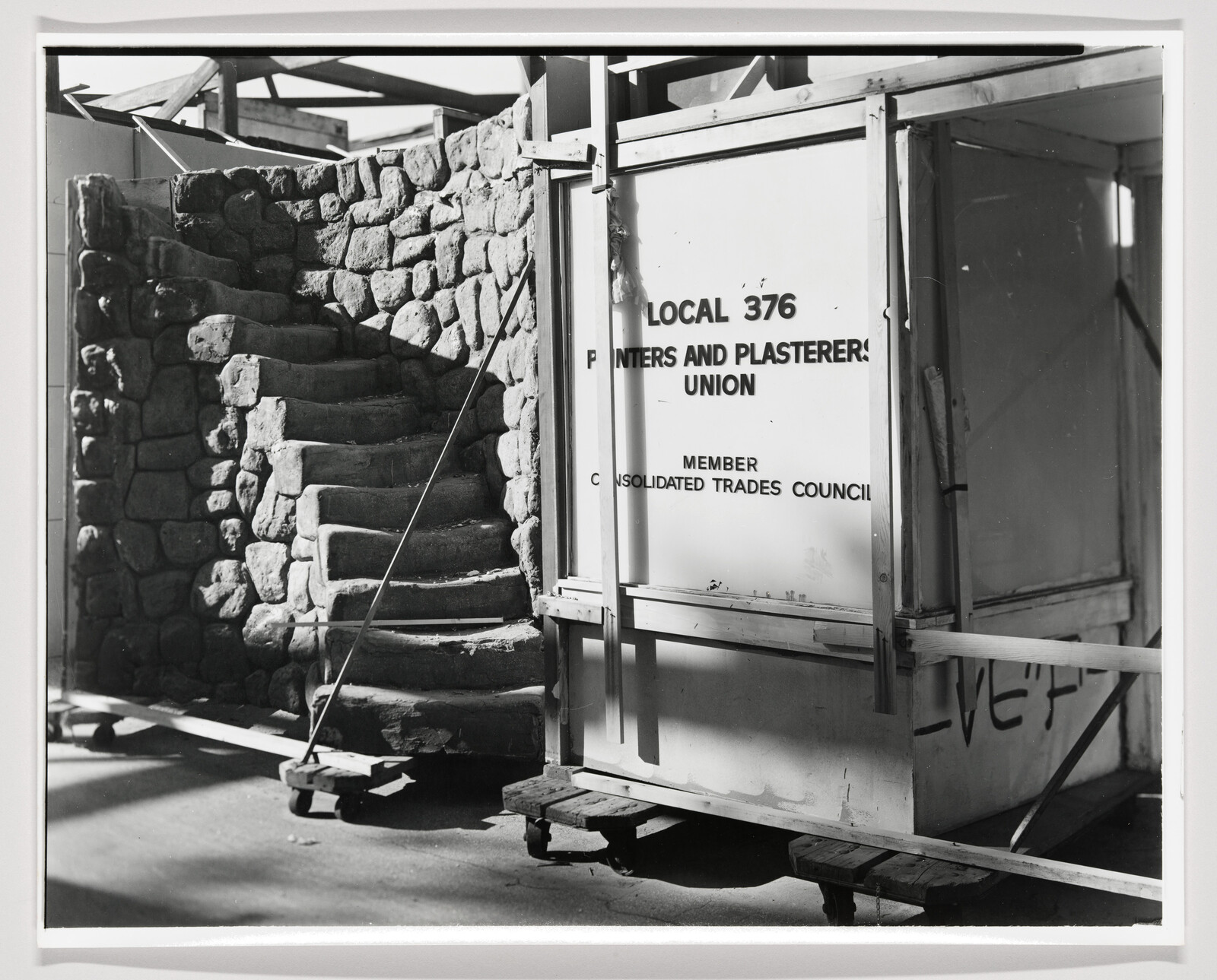 Stone spiral staircase beside a framed booth labeled Local 376 Painters and Plasterers Union.