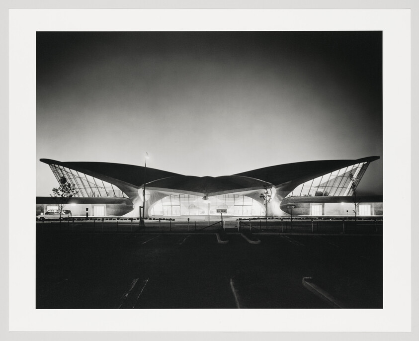 TWA Flight Center terminal with sweeping winged roof lit against a dark sky.