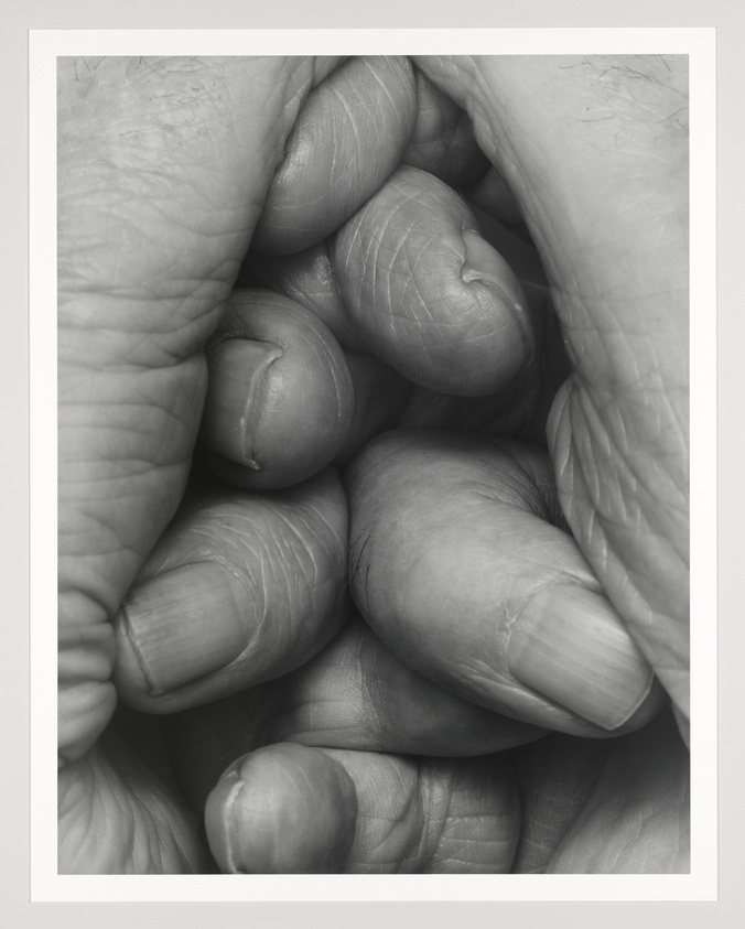 A close up photograph of fingers curled up, intertwined