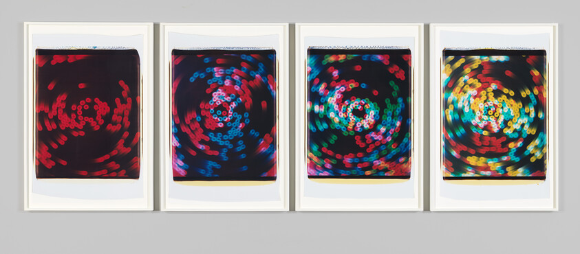 Four framed prints showing swirling bokeh lights progressing from red to multicolored.