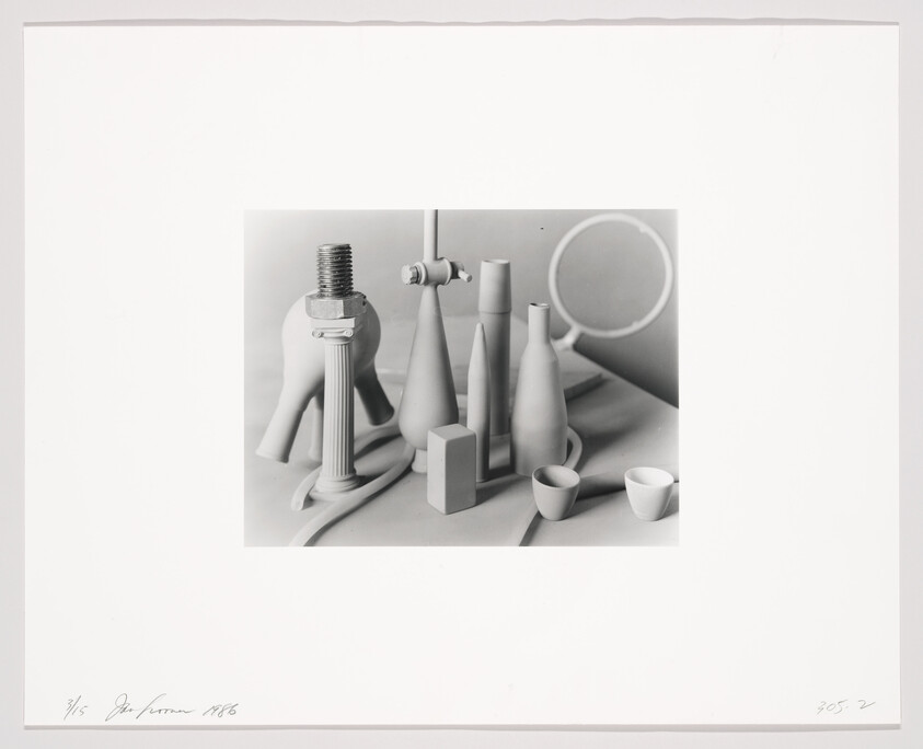 A group of white bottles, cups, a large bolt, and a magnifying glass arranged on a table.
