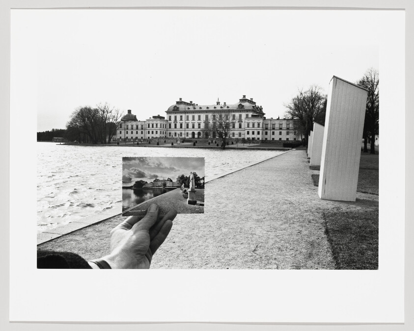 A hand holds a small photograph aligning a historic waterfront palace with its current view.