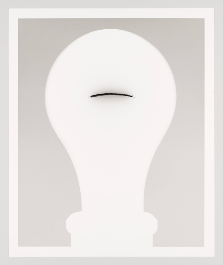 A minimalist artwork featuring a silhouette of a light bulb with a simple, squiggly line representing the filament, set against a plain background with a white border.